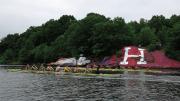 Two Harvard crews (right) row past “The rock,” long contested as a site for Harvard or Yale partisan artwork.