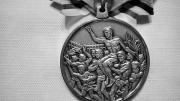 The silver medal he won and has now donated to the College swim team