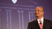 HBS dean Nitin Nohria during his campaign address April 25; a sketch of the iconic Baker Library, with the HBS crest, is projected behind him. 
