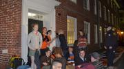 Students sit in front of an entryway to Mass. Hall, as Harvard University police look on.