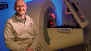 Matthias Nahrendorf seated in front of a PET/CT scanner