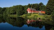 Iconic red-painted River Bend Farm Visitor Center by the Blackstone River and canal