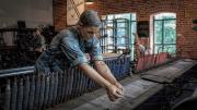 A replica of a textile mill shows life-like statues of workers. 