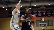 Chris Lewis, ball in hand, drives past opponent