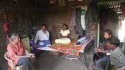 Photograph of Vikram Patel visiting with family members of a farmer in Maharashtra, India, who committed suicide