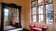 Highfield Hall’s large wall mirror, stained glass, and other architectural details