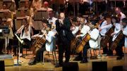 Johnson plays his harmonica with the Boston Pops orchestra behind him.