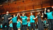 Local composer Nick Page (at left), conductor of the Mystic Chorale, takes a bow with chorus and Collegium Musicum members after they performed his song “Do You Shine” (written especially for Joyful Noise) as an encore. Sharing the applause is Katie Fromm, daughter of the chorus’s co-founder and conductor, Allison Fromm.