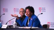 Ruth Simmons sits at a table on the stage with Henry Louis Gates, Jr. 