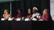 Moderator Jacqueline Bhabha seated at a table with panelists Agnes Binagwaho, Abby Maxman, Natalia Kanem, and Reema Nanavaty.