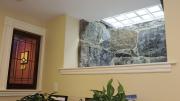 A granite-lined window well at the headquarters of Charlie Allen Restorations Inc. uses frosted glass pavers in the sidewalk to brighten a basement hallway.