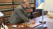International draughts master Alex Mogilyansky with board and checkers in Langdell Library
