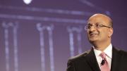 “Let’s begin”: Business School dean Nitin Nohria during his campaign address April 25; a sketch of the iconic Baker Library is projected behind him.