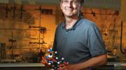 Jack Szostak, in his lab at Massachusetts General Hospital, holds a model of a nucleic acid.