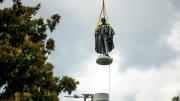 Photograph of John C. Calhoun statue in Charleston in midair being lifted up by a crane