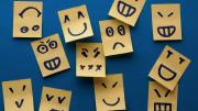Multiple small paper tabs, each decorated with a simple line drawing of a different facial expression