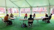 Photograph of teaching a playwriting class under a tent outdoors