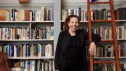 Wendy Lesser standing happily among her books 