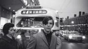 Gram Parsons stands in front of a bus in Harvard Square