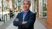 Portrait image of Walter Kim standing on a street with arms folded across his chest