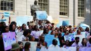 Photograph of student rally against the Supreme Court decision with the John Harvard statue in the background