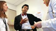 Gawande speaks with patient Ericka Webb (right) at a post-surgical follow-up. Medical student Devon Quasha ’02, J.D. ’06, is at left..
