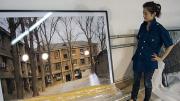 Graduate  student Ren Wei with one of Wang Di’s photographs  at a studio in Beijing. 