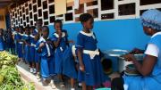 Students at Samrit Academy are served their lunch of kenkey, a popular dish of fermented maize dumplings usually served with soup or stew, in the mid-afternoon. The school caterers receive training through Opportunity International to provide more nutritious and sanitary meals.