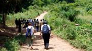 The students and a group of farmers walk along a road to a cacao farm in Bonsaaso district, a part of the UN Millennium Villages Project.