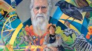 Fichter stands in front of <i>From Orchids to Octopi: The Evolution Mural,</i> which features Charles Darwin.