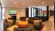 Couches, a flat-screen TV, multicolored chairs, and a brand-new kitchen have transformed the basement of the newly renovated Old Quincy into an appealing community room.