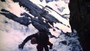 Peter Carman climbing a steep rock and ice gully above Camp One