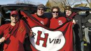 Members of the undefeated 2001 Crimson football team show flags at a 2011 tailgate in New Haven. Jared Lewis &rsquo;02, far left, holds the ancient Little Red Flag, which has been to many Harvard-Yale football games. He designed the new flag, and Kelly Goff made it. It is brandished, from left, by Justin Stark &rsquo;02, Jason Hove &rsquo;02, and Samuel Taylor &rsquo;02.