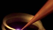 A 3-D printer “draws” a coiled antenna in the air. What allows the printer to work this way is a laser that hardens an “ink” of silver nanoparticles as they emerge from the nozzle.