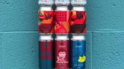 A colorful stack of beer cans against a blue wall