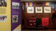 Tack-room gear like bridles, blankets, and saddles is also on display.