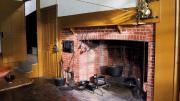 The main house kitchen, with a massive fireplace, and the narrow doorway to the service stairs.