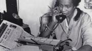 Black journalist Claudia Jones on the phone in the offices of the “West Indian Gazette” in London