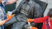 Conservators from Skylight Studios work on the John Harvard statue