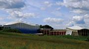 blue skies and green fields and music center building 