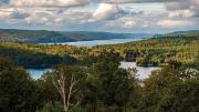 sweeping aerial view of blue sky and Quabbin Reservoir water and mountains 