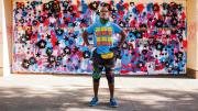 Anwar Floyd-Pruitt standing off a red, white, and blue mural he painted after George Floyd’s death. Floyd's right hand is bandaged after he was attacked while painting the mural.
