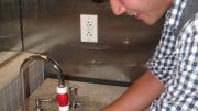 A student using a "Tapminder" device in the men's bathroom