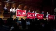 Harvard Alumni Association president Carl Muller ’73, J.D.-M.B.A. ’76 (at left), presents the Class of 2016 with its official banner during the Sanders Theatre portion of Freshman Convocation. 