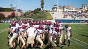 <strong>On the road:</strong> Crimson team members huddled before taking the field at Torero Stadium for Harvard’s first West Coast game since 1949. The University of San Diego’s small but picturesque facility has a seating capacity of 6,000. 