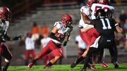 Harvard defensive back Wes Ogsbury maneuvers upfield, holding the football.