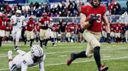 Harvard wideout Jack Cook, on his way to the end zone, runs by an outstretched Yale defender 
