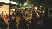 Cruising the Square: A summer crowd watches a street performer in 1987.