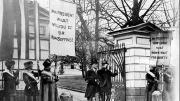 President Wilson passes “Silent Sentinels” as he leaves the White House grounds.