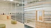 Stacks of  Voss water bottles form a translucent curving wall at a health club.